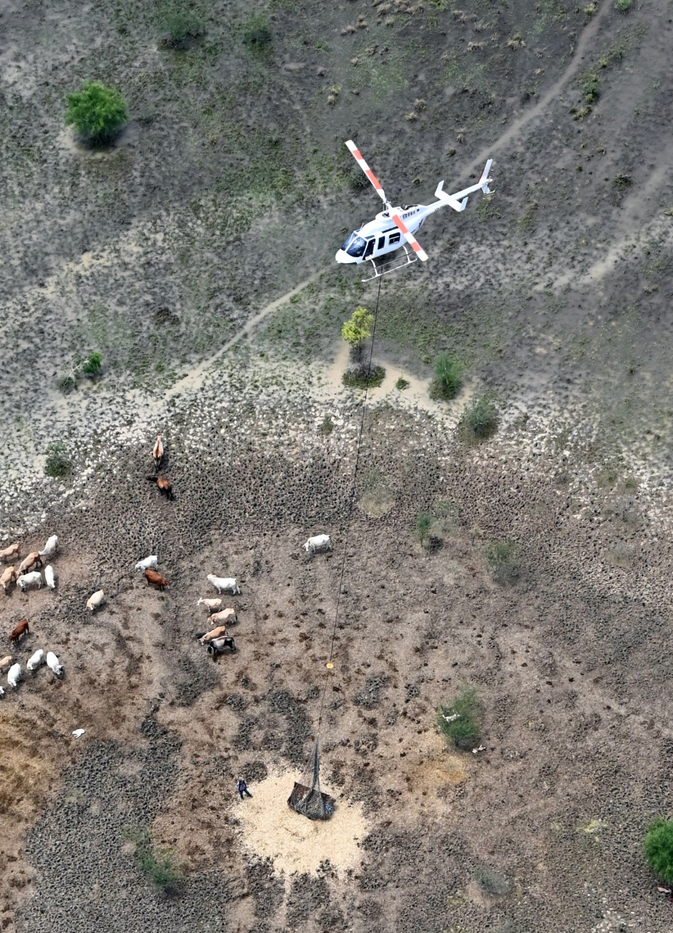 Aerial view of a helicopter delivering a slung load to remote country